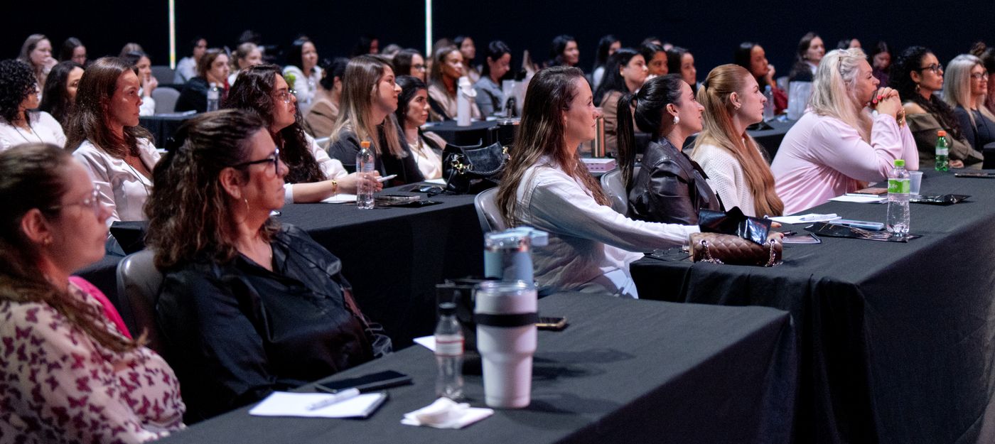 Plateia de mulheres atentas nas mesas durante a primeira edição do Beleza que Cura